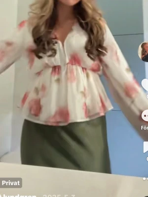 Blommig vit blus med ballongärmar - Söt blus i vitt med rosa blommönster och v-ringning. Använd 1 gång. Blusen har luftiga, transparenta ballongärmar och en lös, flowy passform som ger en romantisk vibe. Perfekt att styla med kjol eller jeans för en trendig look.