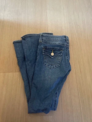 Joey true religion jeans  - Assnygga lågmidjade jeans med guldiga detaljer!!  Köpt för 1399kr💕jätte fint skick förutom lite slitna längst ned (se sista bilden)  Midjemått ca 34cm!  Innerbenslängd ca 78cm🫶🏻      