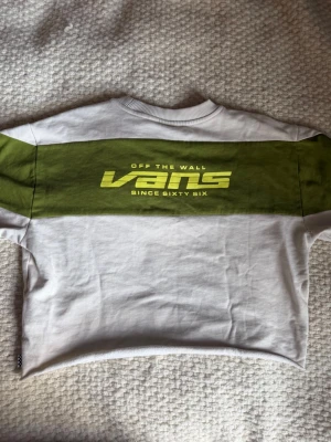 Vit och grön sweatshirt från Vans - Oanvänd sweatshirt från Vans. Den är lite créme vit med grönt mönster som går över rygg och armar. Insidan har ett mjukare material (se på bilden).