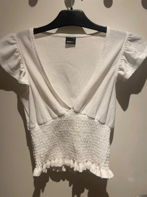 Vit volangtop - Vit smockad blus med volang