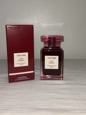 Tom Ford Lost Cherry EdP 100 ml - Tom Ford Lost Cherry Eau de Parfum 100 ml är en lyxig parfym i en elegant mörkröd glasflaska med matchande kartong. Flaskan har en fyrkantig form och ett stilrent lock i samma färg. Doften är känd för sina söta och fruktiga toner med inslag av körsbär.