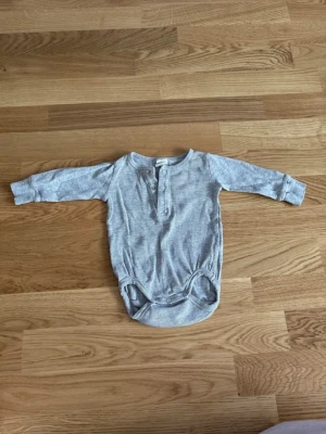 Body bebis H&M stl 62 - Ribbad body med knappar från H&M i storlek 62.  Mycket bra skick. 