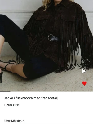 Nakd mockajacka med fransar - Säljer en mörkbrun jacka i fuskmocka med långa fransdetaljer längs ärmar och fram. Jackan har två bröstfickor med lock och knäppning framtill. Perfekt för dig som vill sticka ut med en cool westernstil. Använd fåtal gånger då den är för stor för mig som är 155 cm.