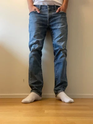 Ljusblå 511 levi’s jeans - Säljer ett par klassiska blå jeans från Levi's i storlek 33/32. Det är slim modell men sitter lite mer löst än vanliga slim jeans. Det är bra skick och jag har gjort lite slitningar på båda benen och på ena fram fickan. Nypris: 1199kr