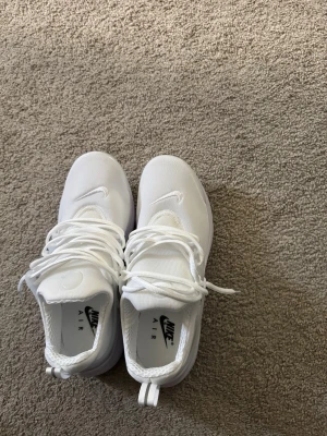 Nike Air prestos - Fräscha helvita Nike Air prestos med lågt skaft. Skorna har en clean design med mesh-ovandel, vita snören och diskret Nike-logga på sidan och tungan. Sulan är vit och ger bra komfort. Perfekta för dig som gillar stilrena och sportiga sneakers.