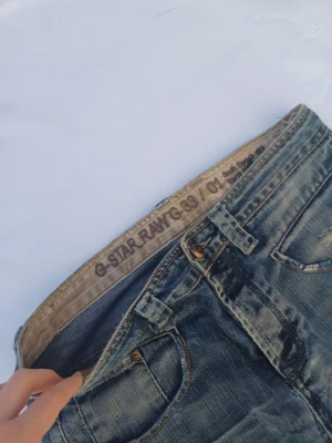 Blå jeans från G-Star RAW - G-Star Raw 33/01 jeans väldigt eftertraktat och populärt. Ny pris=2000kr, vårt pris=749kr. (Originela slitningar från fabriken)
