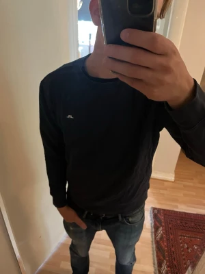 Mörkblå J Lindeberg sweater - En stilren mörkblå sweatshirt från märket J.Lindeberg. Perfekt att ha nu till hösten i stl M. Tveka inte att höra av dig vid frågor! 