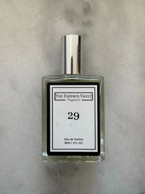 The Essence Vault 29 Eau de Parfum - En stilren parfym från The Essence Vault med nummer 29. Flaskan är rektangulär i genomskinligt glas med en silverfärgad kork och svartvit etikett. Innehåller 30 ml Eau de Parfum. Perfekt för dig som gillar minimalistisk design.