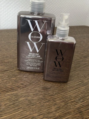Color Wow Dream Coat för lockigt hår - Color Wow Dream Coat för lockigt hår är en fuktgivande spray som hjälper till att definiera lockar och motverka friss. Kommer i två storlekar, båda i stilrena, mörkgrå plastflaskor med spraymunstycke och tydlig vit logga. Perfekt för dig som vill ha mjuka, glansiga lockar.