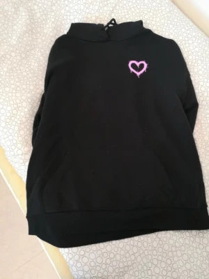 Svart hoodie med tryck & text på baksidan - Väldigt oversized sweatshirt, skulle säga att den passar bäst på M, men allt beror på hur man vill ha passformen, jag har S och 166 cm lång och den är väldigt oversized på mig Lite nopprig och väldigt små vita fläckar/prickar som man ser om man zoomar in på första bilden