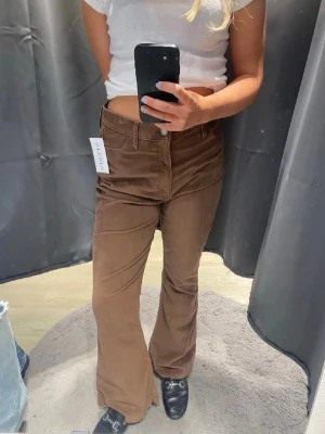 Bruna utsvängda manchesterbyxor från hollister - Snygga bruna manchesterbyxor med utsvängda ben och klassisk femficksmodell. Byxorna har hög midja och stängs med knapp och dragkedja. NYPRIS: 700kr. Säljer pga  Fel storlek