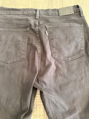 Svarta Levi’s jeans 30/34 modell 724 - Säljer ett par svarta levi’s jeans med raka ben och klassiska bakfickor. Stretchiga