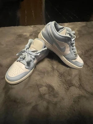 Air Jordan 1 Low Ice Blue / Aluminum - Snygga Jordan 1 Low i ljusblått och vitt. Dammodell, stilrena och populära. Skick: Bra använt skick. Synliga veck på tårna och normalt slitage på sulorna. Inga hål eller stora defekter. Nyligen torkade av. Storlek: EUR 38 Style code: DC0774-141 Säljes då de inte kommer till användning. Pris kan diskuteras vid snabb affär.