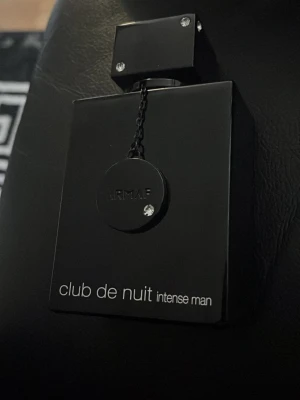 Armaf Club de Nuit Intense Man EdT - Säljer en stilren och maskulin parfym, Club de Nuit Intense Man från Armaf. Flaskan är svart med en fyrkantig form och har en dekorativ kedja med logotypen. Passar dig som gillar eleganta och intensiva dofter. 105 ml och uppskattas 95 ml kvar 