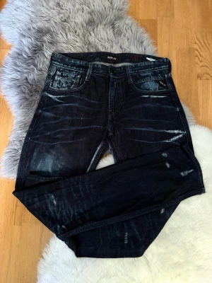 Replay Anbass - Säljer ett par mörkblå jeans från Replay med snygga slitningar och tvättade detaljer. Storlek 30. Jeansen är i mycket fint skick. Kontakta mig om du har några frågor. 