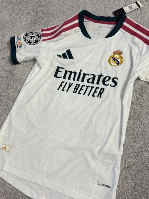 Real Madrid - matchtröja CL - Säljer en vit Real Madrid matchtröja från Adidas med klubbmärke, sponsortryck och CL-märke på ärmen. Skick 10 av 10 helt ny säljer till bra pris. Fraktar direkt 