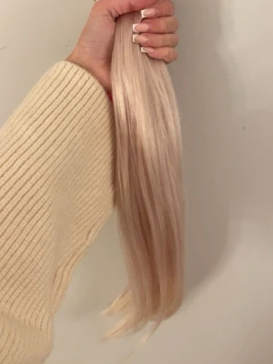  blonda clip ins 45cm - Säljer ett set med långa, raka löshår extensions i en kall blond nyans. Perfekta för dig som vill ha extra volym och längd till håret. Löshåret är silkeslent och ger ett naturligt intryck! Det väger 130gram, ursprungligen 50cm men har klippt till 45 cm då det blev för långt på mig. Endast använt 2 gånger så i superfint skick🩷