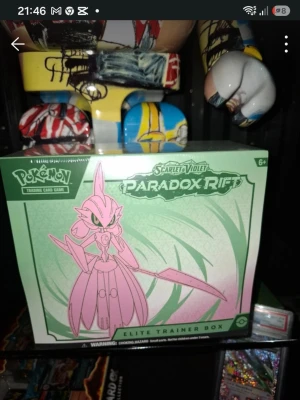 Pokémon Paradox Rift Elite Trainer Box - Pokémon Scarlet & Violet Paradox Rift Elite Trainer Box med motiv av Iron Valiant. Boxen är grön och rosa och innehåller booster packs, sleeves, tärningar och tillbehör för Pokémon Trading Card Game. Perfekt för samlare och spelare som vill utöka sin kortsamling. Helt oröd, pris kan diskuteras men max med någon hundra