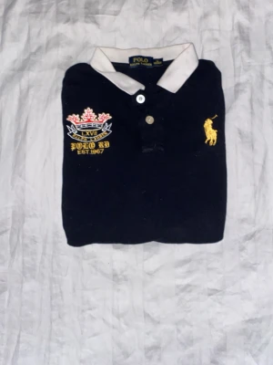 Mörkblå piké med brodyr och nummer - Hej säljer en snygg England och bekväm långärmad piké från Ralph Lauren från äldre kollektioner den sitter som en xs  hör av er vid frågor