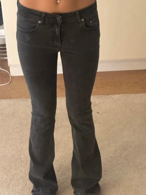 Svarta bootcut jeans  - Säljer ett par svarta bootcut jeans med hög midja och klassisk femficksmodell. Jeansen har en lätt utsvängd passform nedtill och är tillverkade i ett mjukt denimtyg med stretch. Perfekta för dig som gillar en tidlös och snygg look.