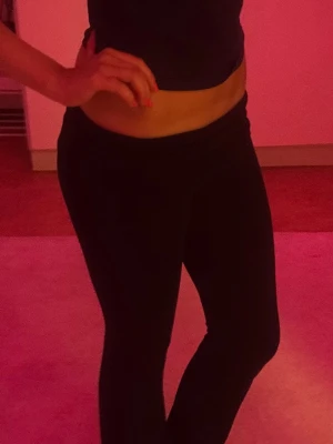 Mörkblå yoga pants  - Säljer ett par svarta leggings med utsvängda ben och hög midja. De är stretchiga och sitter tight upptill men blir vidare nedtill för en snygg siluett. Perfekta till crop tops eller oversized tröjor.