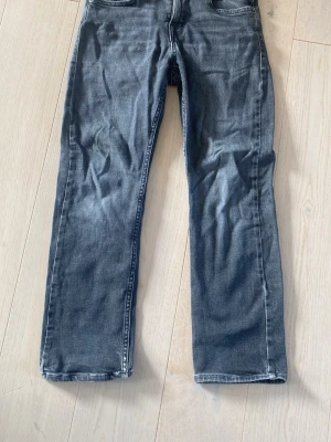 Svarta raka jeans - Snygga svarta jeans med rak passform och klassisk femficksdesign. Jeansen har en tvättad look och är tillverkade i denim med lätt stretch för extra komfort. Perfekta för en avslappnad och trendig stil.