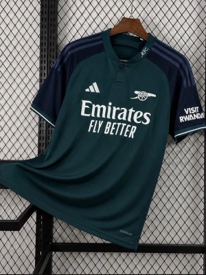 Mörkgrön Arsenal matchtröja  - Snygg mörkgrön Arsenal matchtröja från Adidas med mörkblå ärmar och vita tryck. Tröjan har klubbens logga och 'Emirates Fly Better' på bröstet. Tillverkad i lätt och funktionellt material, perfekt för träning eller match.