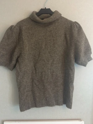 Brun stickad tröja från Zara - Mysig brun stickad tröja från Zara med korta puffärmar och hög krage. Perfeckt nu till hösten.🍂