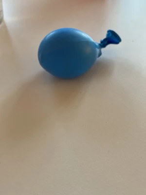 Blå stressboll av ballong - En blå stressboll gjord av en ballong fylld med mjukt material. Perfekt att klämma på när du behöver slappna av eller fokusera. Enkel att ta med sig och använda när som helst. Rund form och elastiskt material.