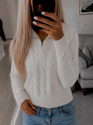 Vit stickad tröja från NA-KD - Säljer en skitnsygg krämvit kabelstickad tröja från NA-KD med halv dragkedja framtill. Sitter jättefint på och är perfekt nu inför hösten!💕(Kan skicka mått privat) Liten fläck syns på sista bilden 