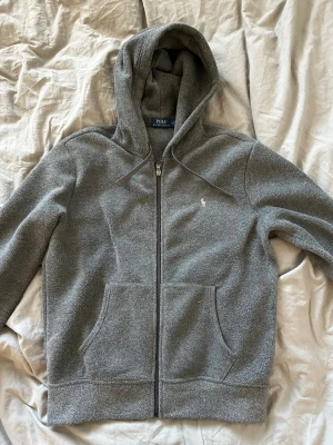 (SÄLLSYNT) Polo Ralph Lauren grå teddy zip  - Schysst oanvänd mörkgrå ralph lauren zip i ett mörkgrått teddy material. Väldigt sällsynt och säljs till ett bra pris. 