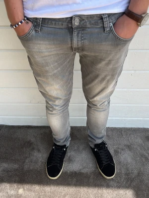 Nudie jeans ljusgrå  - Tjenare! Säljer dessa riktigt bekväma och snygga ljusgrå nudie jeans med storleken 34/32 med en lite bredare och go passform så du har utrymme. 98% bomull 2% elastan. Riktigt bra skick utan defekter. Hör gärna av dig! 