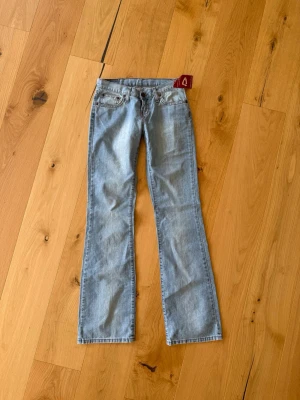 Lågmidjade bootcut jeans - Ljusblå bootcut jeans från Dallas jeans med klassisk femficksdesign och låg midja. Jeansen har en snygg tvätt och raka ben som går ut lite nedtill. Helt oanvända med prislappen kvar. Strl 28/34, som en S.🩷