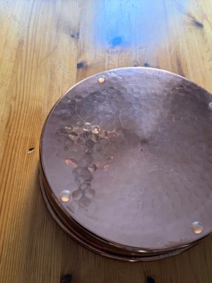 Rund kopparform med handtag - Säljer en rund form i koppar med hamrad yta och metallinsida. Formen har två rejäla ringhandtag på sidorna och passar perfekt som dekoration eller serveringsfat. Klassisk design som ger en rustik känsla till hemmet.