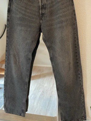 Snygga grå Jack & Jones Jeans  - Säljer ett par grå jeans från Jack & Jones Relaxed/Chris rakmodell med lite baggy style. Jeansen har en tvättad vintage-look och är tillverkade i denim. Perfekta för dig som gillar en avslappnad och tidlös stil.