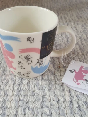 Muminmugg med rosa och blått motiv - Felfri mugg med både etikett och lapp. Säljer fler Muminmuggar så kika gärna också på mina övriga annonser. Packar mycket noggrant. 