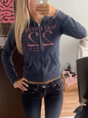 Mörkblå Hollister hoodie med dragkedja - Mörkblå hoodie från Hollister med dragkedja framtill. Den är i gott skick men trådarna sitter inte helt slätt på vissa ställen (bild 3) Men det är inget märkbart. Storlek XS