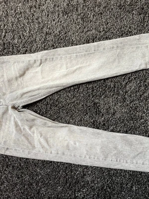 Ljusgråa skinny jeans - Säljer ett par ljusgråa skinny jeans med klassisk femficksdesign. Jeansen har smal passform och är tillverkade i ett mjukt denimtyg som sitter snyggt längs benen. Perfekta för dig som gillar en stilren och enkel look. Kom med frågor Pris kan diskuteras 