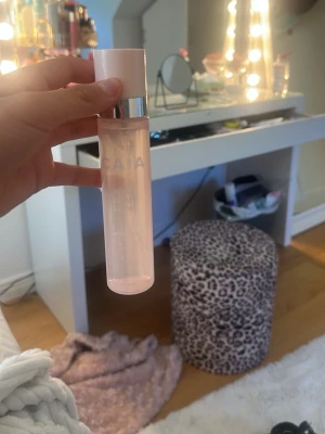  CAIA settingspry - Fräsch face mist från CAIA i en stilren, cylinderformad rosa plastflaska med vit kork och silverdetalj. Perfekt för att återfukta och ge glow till huden under dagen.