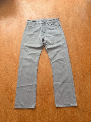 Levi's 501 gråa raka jeans, storlek W33 L32 - Jättefint skick.  Midja: 40cm Gren: 26cm Total längd: 101cm Benöppning: 20cm
