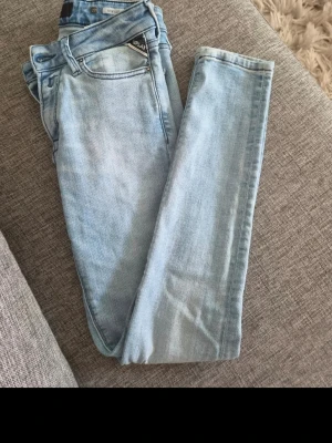 Ljusblå skinny jeans från Replay - Säljer ett par ljusblå skinny jeans från Replay, modell New Luz. Jeansen har klassisk femficksdesign, dragkedjegylf och är tillverkade i stretchigt denimtyg för en bekväm passform. Perfekta till en avslappnad look..storlek 27×30