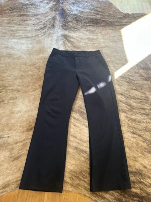 Svarta kostymbyxor från Lindex - Snygga svarta kostymbyxor från Lindex . Byxorna har en klassisk look och är tillverkade i ett mjukt, vävt material som ger en stilren känsla. Perfekta för dig som vill ha en clean och enkel stil.