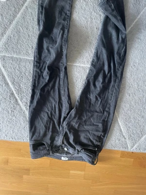 Grå jeans från H&M ESSENTIALS - Snygga grå jeans från H&M ESSENTIALS No.2 med regular fit. Klassisk femficksmodell och knappgylf. Perfekta till en avslappnad stil och passar till det mesta. Tillverkade i bomull med en skön känsla.