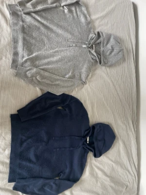 Mörkblå och grå hoodie med huva - En stilren mörkblå och grå hoodie med huva. Hoodien har långa ärmar och ribbade muddar vid ärmslut och nederkant. Perfekt för en avslappnad look och enkel att matcha med jeans eller joggers. Köp båda för 200 eller en för 150. Tröjorna är noppriga så priset kan diskuteras! 