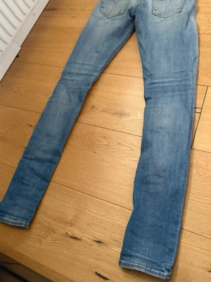 Ljusblå skinny jeans med slitningar - Snygga ljusblå skinny jeans med lätt slitna detaljer och klassisk femficksdesign. Jeansen har smal passform hela vägen ner och är perfekta för en avslappnad och trendig look. Materialet är mjukt och stretchigt för extra komfort.