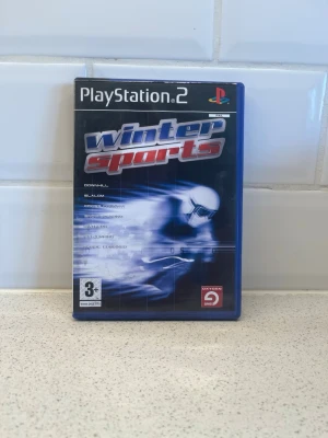 Winter Sports till PlayStation 2 - Winter Sports är ett sportspel till PlayStation 2 där du kan tävla i olika vintersporter som slalom, störtlopp och längdskidåkning. Omslaget är blått med en skidåkare i fart och spelet kommer i ett klassiskt plastfodral. Fungerar toppen!