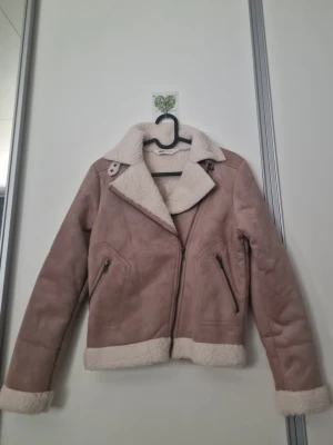 Beige teddyjacka från H&M storlek 160/80 - Säljer en beige teddyjacka från H&M med mjukt, fluffigt foder och krage i offwhite. Jackan har dragkedja, bred krage och muddar i samma material. Utsidan är i mockaimitation och insidan är supermjuk teddy. Perfekt för kalla dagar!