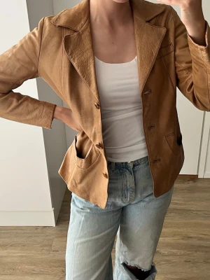 Brun skinnjacka - Vintage brun skinnjacka med klassisk krage och knäppning framtill. Säljer då den är något för liten för mig. Finns tecken på användning men tror den kan se ut som så gott som ny om man bara ger den lite kärlek och insmörjning
