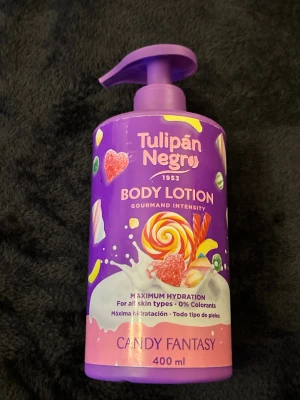 Tulipán Negro Body Lotion Candy Fantasy - Body lotion med doft av godis från Tulipán Negro. Flaskan är lila med färgglada godismotiv och har en praktisk pump. Innehåller 400 ml och passar alla hudtyper. Ger maximal återfuktning och innehåller inga färgämnen.
