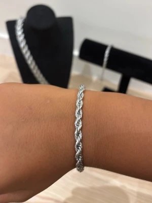 Silver Cordell armband - Snyggt armband i silverfärg med flätad design. Armbandet har en klassisk karbinhake som lås och passar perfekt för dig som gillar stilrena accessoarer. Materialet ser ut som metall och ger ett elegant intryck.